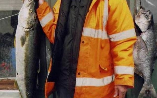 Freddy Sumner (79) staan hier met sy twee behoorlike visse, ‘n geelstert (20kg) en ‘n blouvis (15kg) wat nie sommer hier gevang is nie. Freddie gaan elke 4 jaar saam met die SA Agulhas na die Suid-Atlantiese see waar hy op die eiland, Tristan Dacunha, vir sy kinders gaan kuier. Hierdie twee bielies het hy gevang toe hulle met ‘n boot uit is om kreef te trek. 